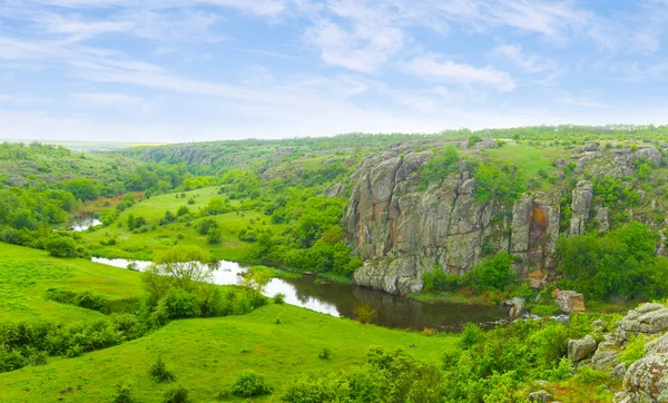 曇り空の下緑の丘の間の小さな穏やかな川の流れ — ストック写真