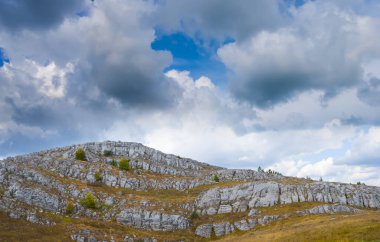 Yoğun kümülüs bulutları altında dağ yaylası