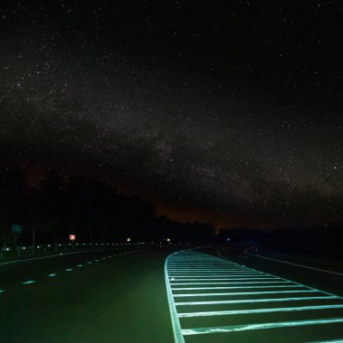 Gecenin altında asfalt yol Yıldızlı gökyüzü