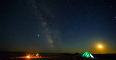 Yıldızlı gökyüzünün altında kamp ateşi olan turistik kamp, gece kampı sahnesi