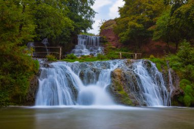 Nehirdeki su şelalesi ormanda hızla akıyor.