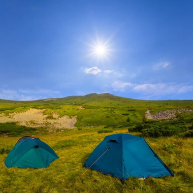 Güneşli bir günde Yeşil Dağ Vadisi 'ndeki turistik kamp, dağ yolculuğu sahnesi.
