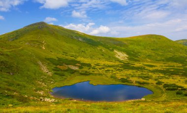 Yeşil dağ kasesinde küçük mavi bir göl