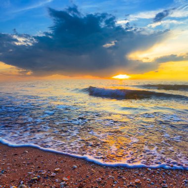 Kumlu sahil dramatik günbatımı, yaz tatili sahnesi