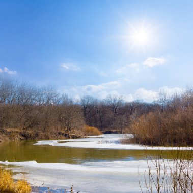 Donmuş nehir güneşli bir günde karla kaplı, mevsimlik açık hava manzarası