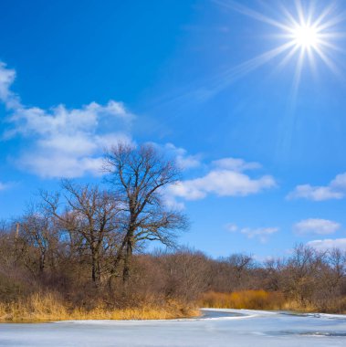 Donmuş nehir güneşli bir günde karla kaplı, mevsimlik açık hava manzarası