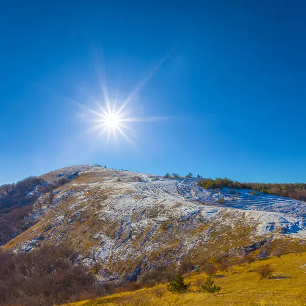 snowbound mountain ridge under a sparkle sun