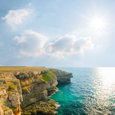 Yazın güneşli bir günde kayalık sahilli deniz koyunda