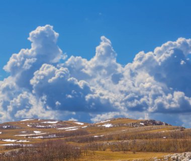 Yoğun bulutlu gökyüzünün altındaki dağ vadisi