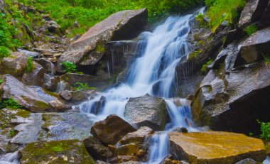 Dağ nehrindeki mavi şelaleye yakın.