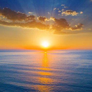 Sakin deniz koyunda dramatik günbatımında