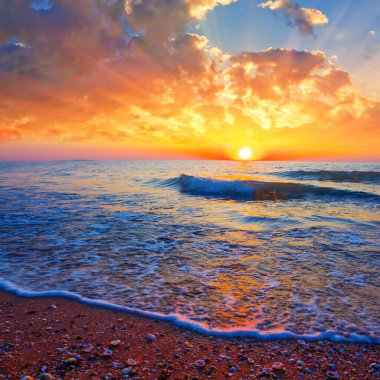 Kumlu deniz plajı dramatik günbatımında, akşam deniz kıyısı sahnesinde