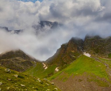 Sis ve yoğun bulutlarda yeşil dağ sırtı