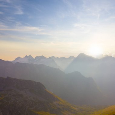 Işıl ışıl güneşin altında sisli dağ sırtı