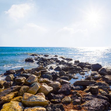 Yazın güneşli bir günde taşlı deniz kıyısında