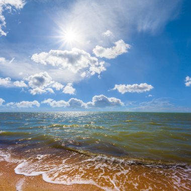 Güneşli bir günde kumlu sahil, yaz tatili sahnesi.