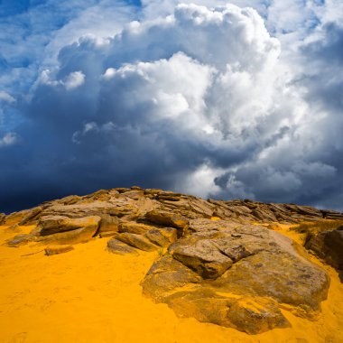 Kumlu tepe Yoğun bulutların altında devasa taşlar yığını