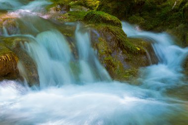 Küçük bir dağ deresi taşların üzerinden akıyor.