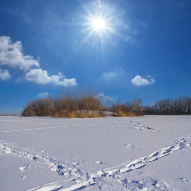 Işıl ışıl güneşin altında, geniş karla kaplı.