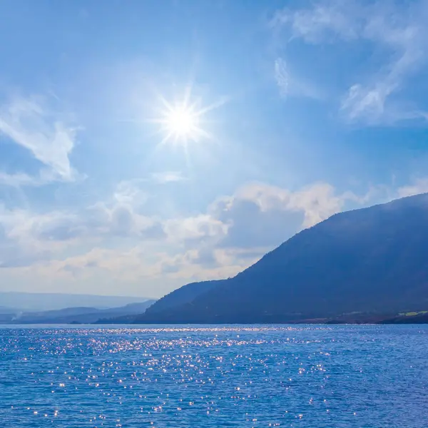 Dağ siluetiyle sakin bir deniz koyunda