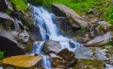 Dağ nehrindeki mavi şelaleye yakın.