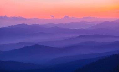 Dağ sırtı silueti alacakaranlıkta sisli