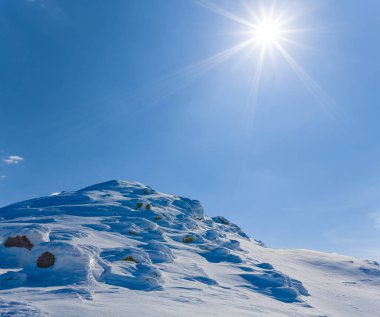 Işıl ışıl güneşin altında, karlı dağ sırtı