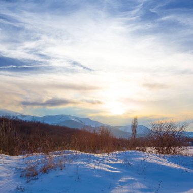 Dramatik günbatımında kar altında kış vadisi
