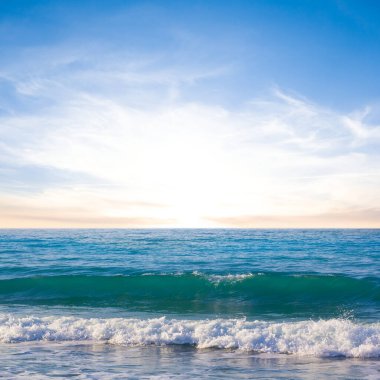 Güneş batarken dalgalı zümrüt deniz kıyısı