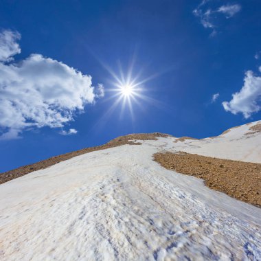 Karda dağ zinciri Parlak bir güneşin altında, Bahar dağı seyahat sahnesi