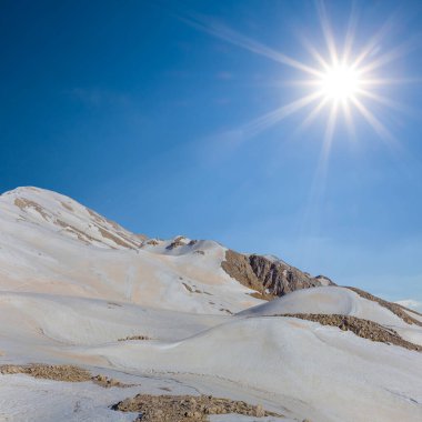 Karda dağ zinciri Parlak bir güneşin altında, Bahar dağı seyahat sahnesi