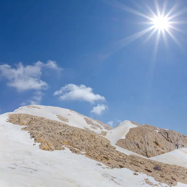 Karda dağ zinciri Parlak bir güneşin altında, Bahar dağı seyahat sahnesi