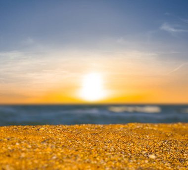 Mavi bulutlu gökyüzünün altında kumlu deniz plajı dramatik günbatımında