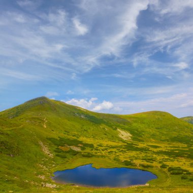 Yeşil dağ vadisinde küçük mavi bir göl