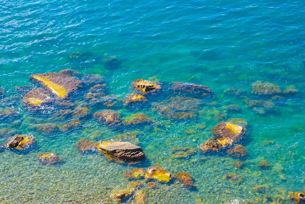 Yukarıdan zümrüt deniz körfezi kıyılarına taş yığınları, güzel deniz doğal arka planı