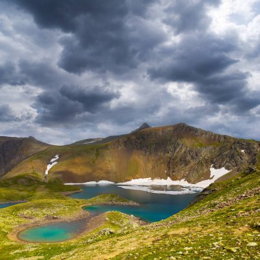 Zümrüt göl mavi bulutlu gökyüzünün altında yeşil bir dağ kasesinde