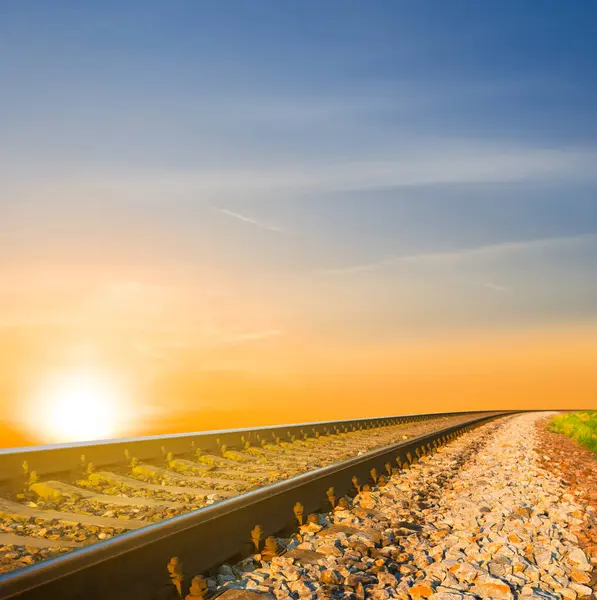 Yakın demiryolu gün batımında uzaklaşıyor.