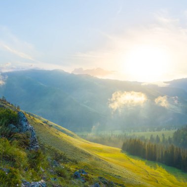 Geniş yeşil dağ vadisi gün batımında