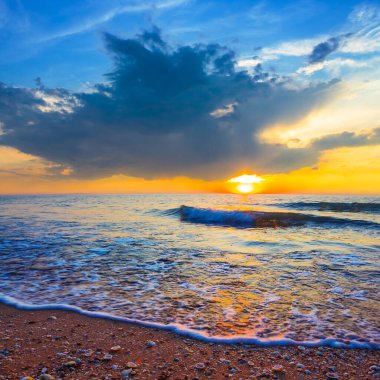 Geniş kumlu sahil dramatik günbatımı, yaz tatili sahnesi