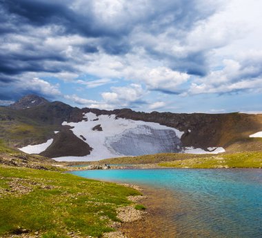 Yeşil dağ vadisindeki küçük göl. Yoğun sis ve bulutlar içinde.