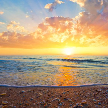 Geniş kumlu sahil dramatik günbatımı, yaz tatili sahnesi