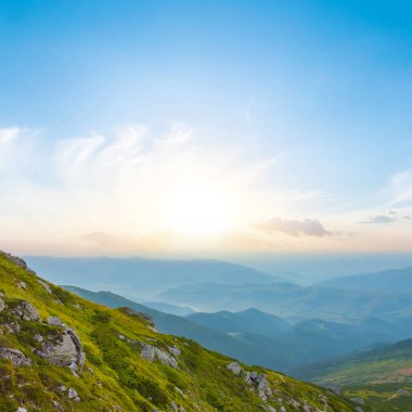 Yeşil dağ vadisi bulutların içinde gün doğumunda, yaz sabahı dağ yolculuğu sahnesinde