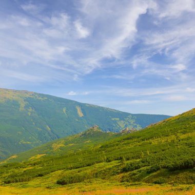 Güzel yeşil dağ omurgası Mavi bulutlu gökyüzünün altında