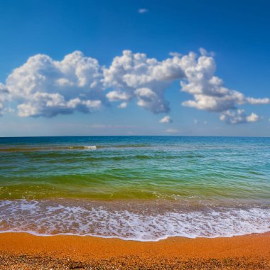 Geniş kumlu deniz plajı bulutlu bir gökyüzü altında, yaz tatili sahnesi