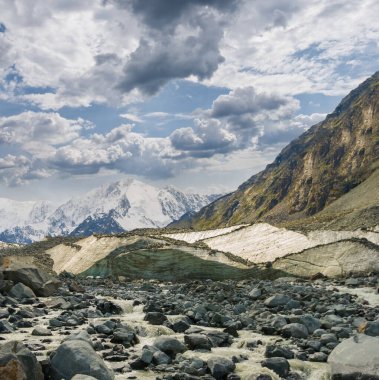 Yoğun bulutlu gökyüzünün altında karda dağ sırtı