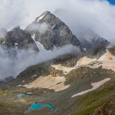 Karlı dağ sırtı sisli ve yoğun bulutlu, dağ yolculuğu sahnesi