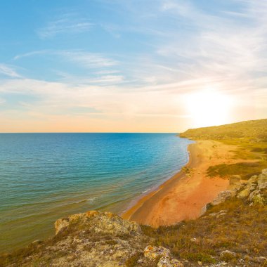 Kumlu deniz koyunda dramatik günbatımında