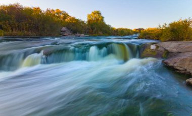 Nehir kanyondaki büyük taşların arasından akıyor.