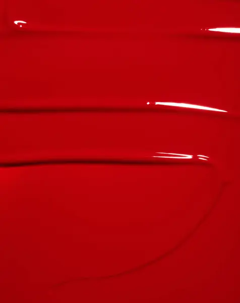 Siyah arka planda kırmızı boya lekesi, kırmızı ruj lekesi, parlak renkli kozmetik ürün vuruşu, akryl guaj yağı boya dokusu, kozmetik ürün dokusu veya güzellik ürünü dokusu.