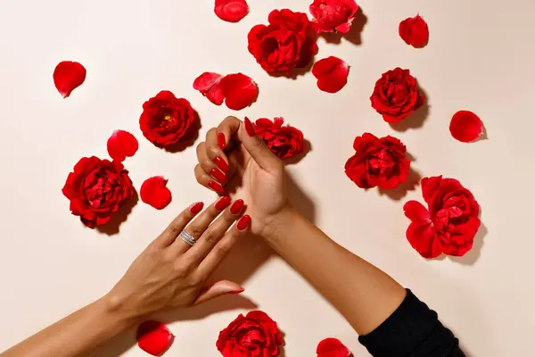 hands with red rose petals, hands with red manicure